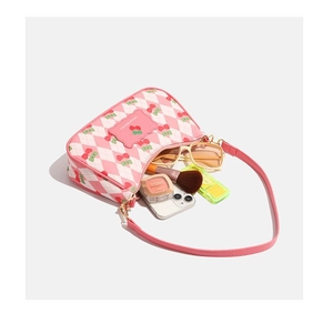 Vue de dessus du sac bandoulière cerise montrant l'espace intérieur et accessoires