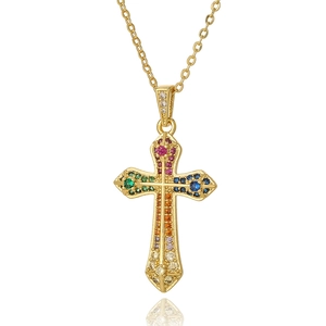 Fashionable gold cross pendant necklace with colorful cubic zirconia on a white background