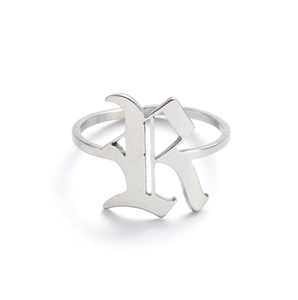 Close-up of a vintage stainless steel ring featuring a gothic silver letter R design
