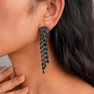 Macro shot of long black zircon tassel earrings with faceted stones on a model