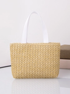Detail of hand-woven beige tote bag with white canvas handles and textured diamond pattern