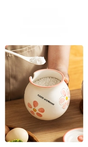 Close-up of ceramic seasoning jar with daisy pattern and spoon for kitchen storage
