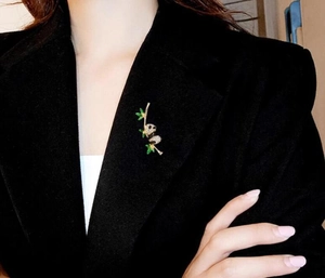Detailed view of a panda brooch with black white crystals on a dark suit lapel