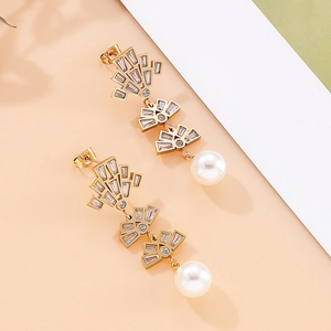 Detail of hollow fan-shaped earrings with zircon crystals and large white pearls