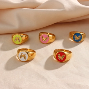 Five gold 18K plated stainless steel enamel rings with butterfly zircon accents on silk