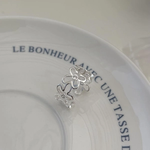 Close-up of silver daisy ring with a sparkling zircon stone on a white ceramic tray