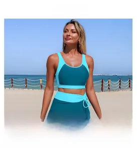 Detail of color-block racerback tankini top and side-tie skirted bikini bottom