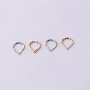 Détail d'anneaux de septum en V en or et argent avec des zircons clairs brillants