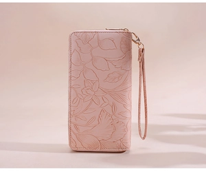 Detailed macro view of pink leather wallet featuring 3D embossed floral patterns