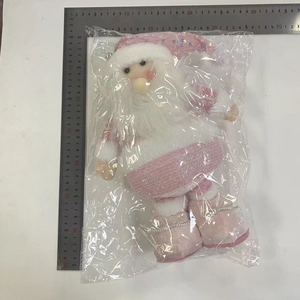 Detail of pink Santa plush toy with sequin hat measured against metal rulers for size