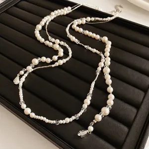 French vintage pearl and crystal beaded long necklace displayed on a black jewelry tray