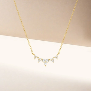 Detail view of gold S925 sterling silver necklace with sparkling three-stone diamond pendant