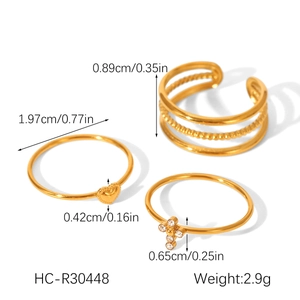 Three-piece gold titanium steel ring set with hollow design, heart detail, and zircon cross