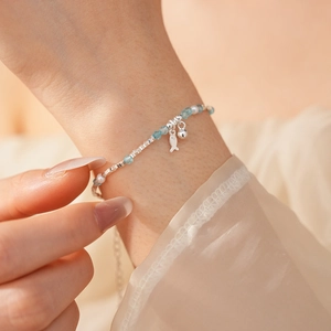 Detailed close-up of 925 silver bracelet with blue crystal beads and pearls on wrist