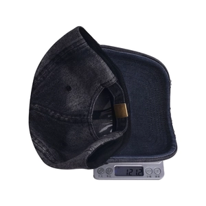 Close-up of distressed denim baseball cap on a digital scale showing 121.2g weight