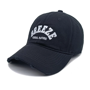 Dettaglio del ricamo Breeze e della visiera usurata su cappello da baseball nero