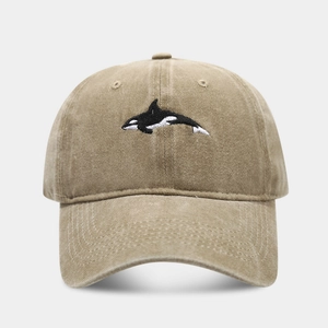 Macro detail of orca embroidery on washed cotton twill baseball cap fabric