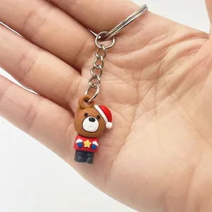 Close-up of mini Christmas bear keychain with red star sweater and festive hat
