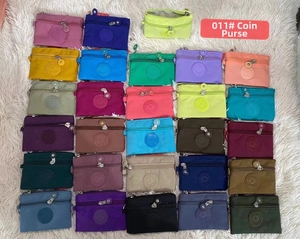 Flat lay of colorful nylon mini coin purses with dual zippers and circular patches
