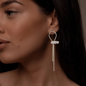 Model wearing elegant gold tassel earrings with freshwater pearls and zircon accents