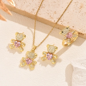 Close-up of golden bear jewelry set with pink heart gems and micro-pave zircons