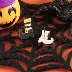 Detail shot of wooden witch boot earrings on a spider web for Halloween styling