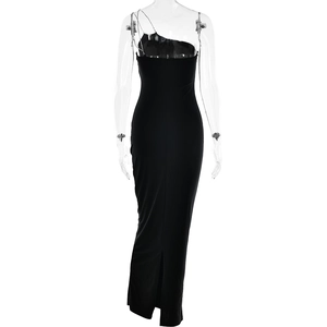 Détail d'une robe longue noire moulante avec bandoulière en chaîne et fente à l'arrière