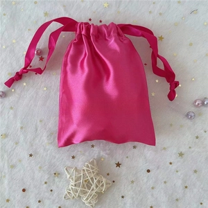 Detail of rose red satin drawstring gift bag with ribbon closure and smooth finish