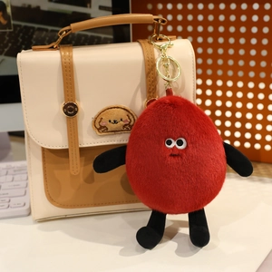 Detail of creative red plush peanut doll keychain accessory on leather bag
