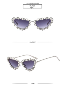 Detail of silver cat eye sunglasses with rhinestones and gray gradient lenses