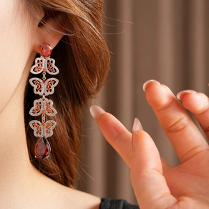 Gros plan d'une boucle d'oreille papillon vintage avec pampille en zircon rouge