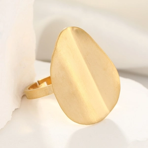 Close-up of golden stainless steel ring with a large oval brushed metal surface