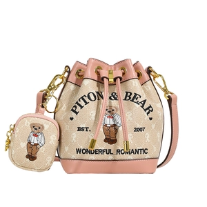 Beige canvas bucket bag with pink leather trim and cartoon bear print, set with small pouch