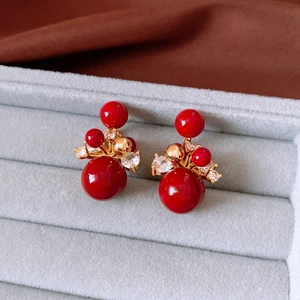 Macro view of red bead earrings with 18K gold plating and zircon inlay in jewelry box