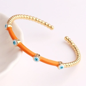 Chic gold-plated Evil Eye open bangle with vibrant orange enamel and bead chain details