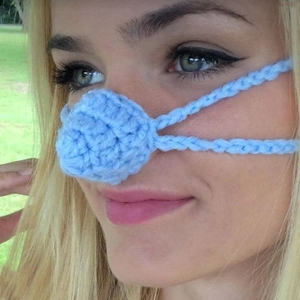 Close-up of a hand-knitted light blue nose warmer accessory worn by a female model