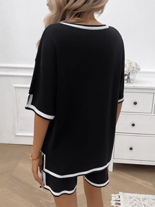 Detail view of black knit two-piece lounge set with contrast white stripe piping on the back