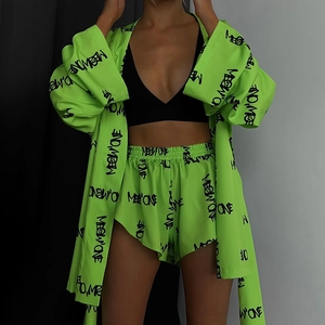 Detail view of neon green lounge set with black MEOW ONE lettering and elastic waistband