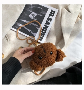 Detail of cute brown plush bear head crossbody bag with soft lamb wool texture on beige fabric