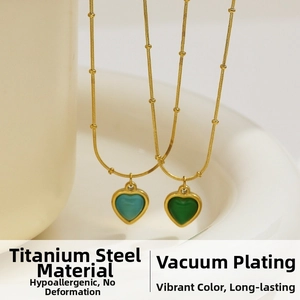 Detail of heart pendants in green and teal with vacuum plated gold titanium steel chain