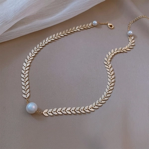 Close-up of elegant leaf-shaped chain necklace with a large white pearl pendant detail