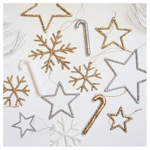 Close-up of champagne and silver sequined Christmas tree ornaments in star and snowflake shapes
