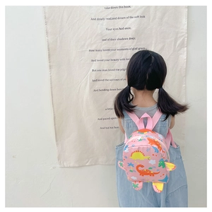 Detail of pink kids backpack featuring cute dinosaur prints and side 3D decorative fins