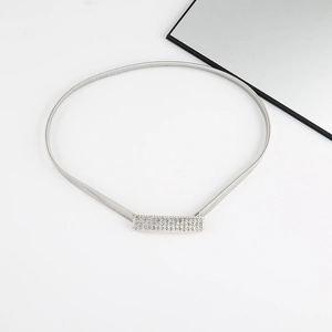 Detailed view of silver elastic metal belt with rectangle rhinestone buckle on white surface