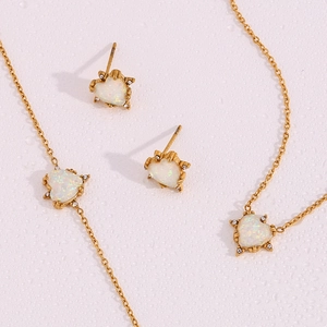 Detail of heart-shaped opal jewelry set with gold finish and crystal accents
