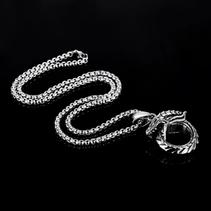 Vue détaillée du collier Ouroboros en acier titane avec pendentif dragon sur fond noir