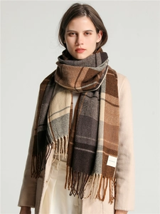 Close-up of thick plaid scarf texture with tassel edges and Self Service label
