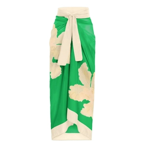 Detail of green floral wrap beach skirt featuring white waist tie and ruffled trim edges