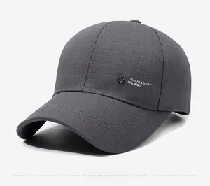 Close-up of the metal logo and fine twill cotton texture on the dark gray baseball cap