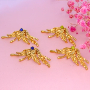 Detail of irregular gold butterfly earrings with blue and green natural stones